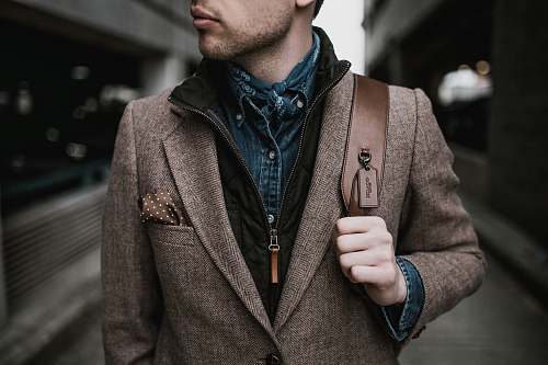 person man in brown suit jacket carrying brown backpack human