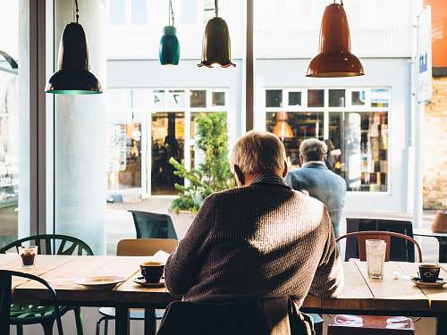person man in chair with table beside coffee cafe