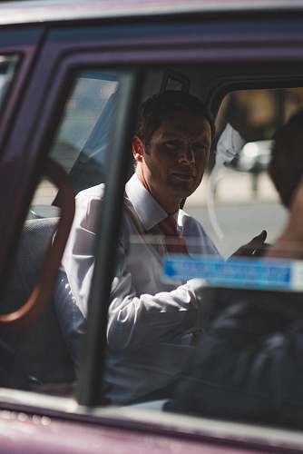 person man in white dress shirt sitting inside vehicle london