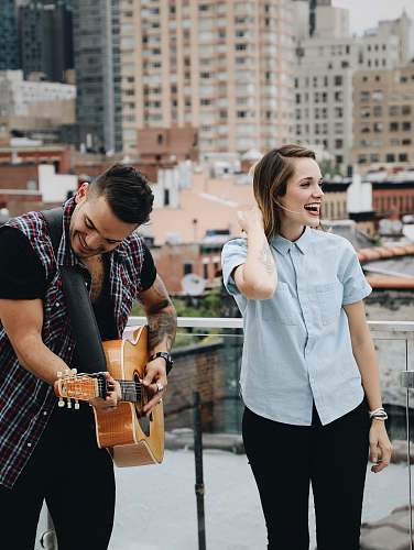 person man playing guitar beside singing woman music