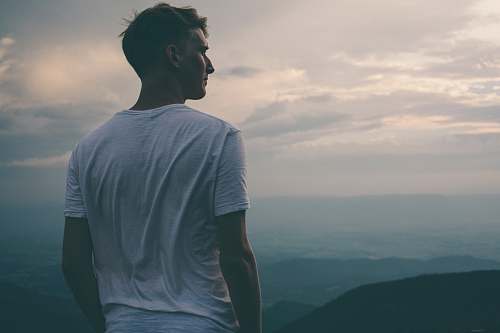 person man standing facing mountains during sunset human