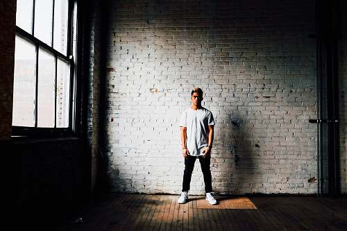 person man standing in front of white wall human