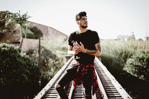 person man standing on railroad near plants human