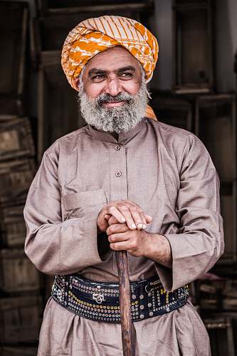 human man standing while holding brown wooden walking cane saudi arabia