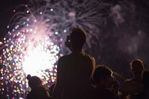 fireworks man taking picture of firecracker night