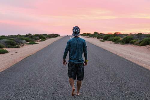 person man walking on gray concrete road road