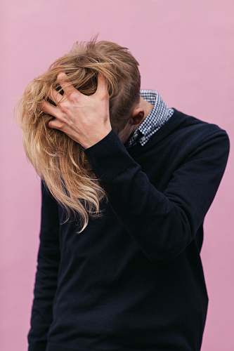 person man wearing black crew-neck sweatshirt with hand running through hair hair