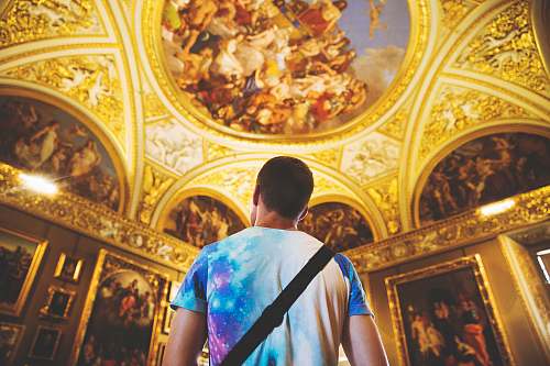 person man wearing multicolored shirt standing inside room human