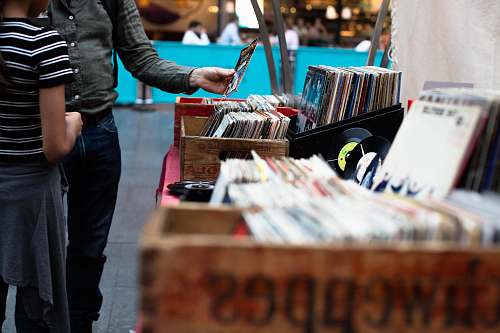 human men standing in front of vinyl record sale person