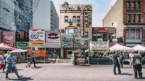 human people walking in street near buildings billboard