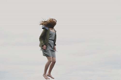 person photography of woman covered with her hair while jumping human