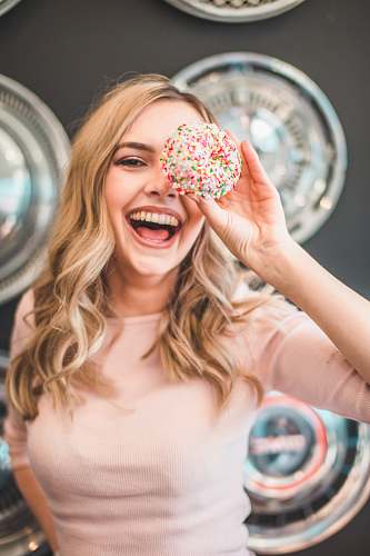 woman shallow focus photography of woman holding doughnut girl