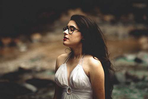 woman shallow focus photography of woman in white halter top facing sideways female