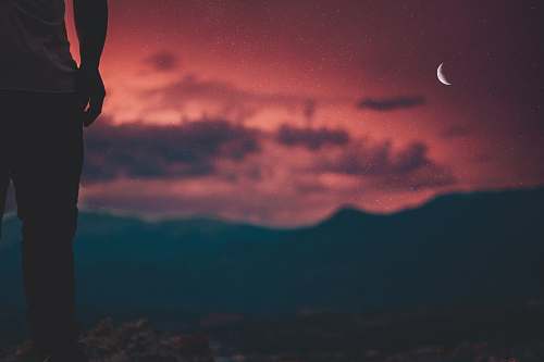 person silhouette of man looking at moon sky