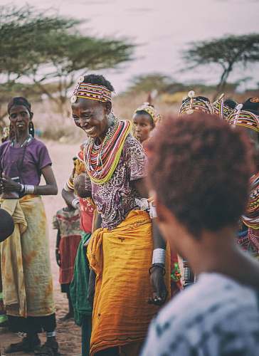 person smiling woman dancing around people in tribe during daytime human