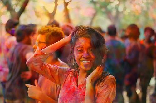 festival smiling woman holding her head and hair during daytime woman