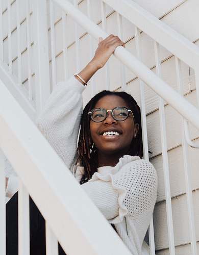 human smiling woman sitting on white stairs woman