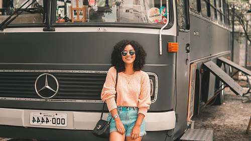 person smiling woman standing in front of Mercedes-Benz bus human