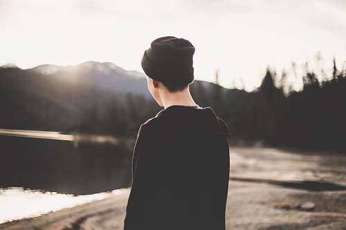 person tilt shift lens photography of man standing near body of water human