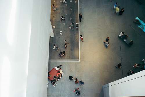 sit top-view photography of people beside white concrete building aerial