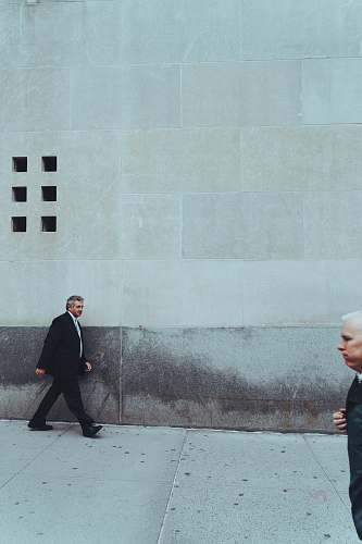 person two man walking near building suit