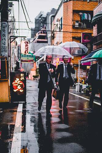 umbrella two men in black suit holding transparent umbrellas walking in the street canopy