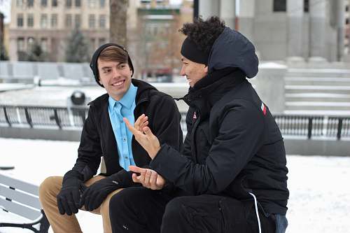 person two men talking while sitting on bench human