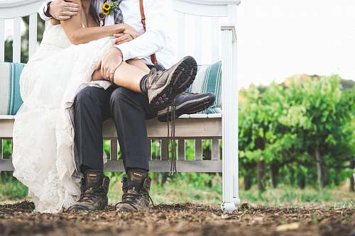 wedding woman and man sitting on white wooden bench human