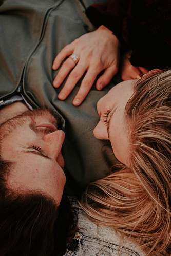 human woman beside man lying on gray textile couple