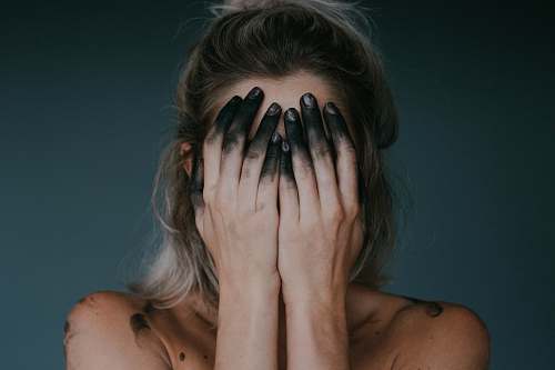 person woman covering face with both hands closeup photography human