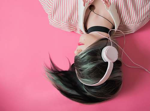 pink woman covering her hair and wearing headphones girl