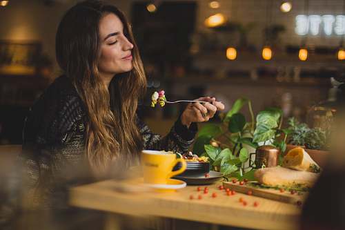 person woman holding fork in front table food