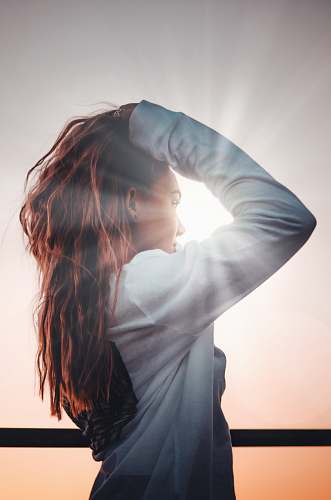 human woman holding her hair during sunset woman