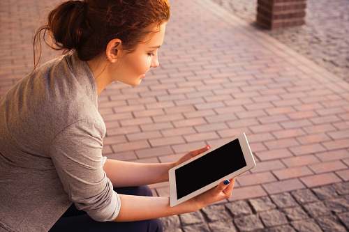 person woman holding white iPad woman