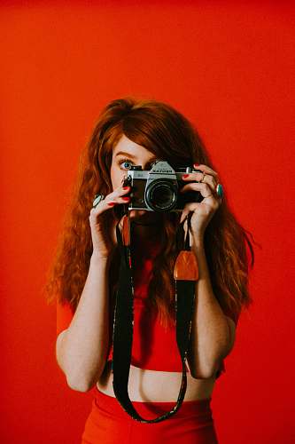 person woman in red top and bottoms holding Pentax camera human