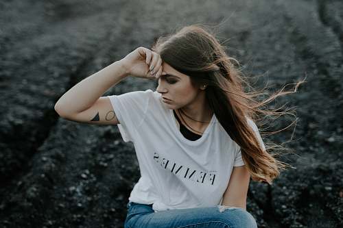person woman in white shirt sitting on ground girl