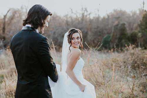 person woman in white wedding dress and man in black suit jacket wedding