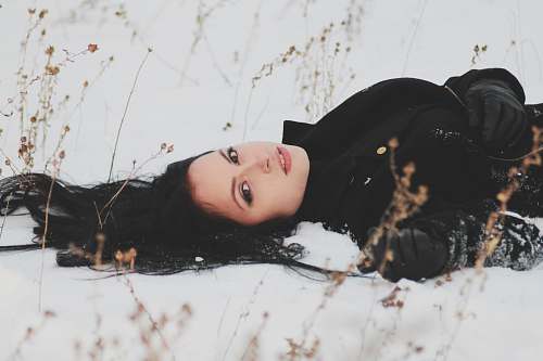 person woman laying on snowy ground woman