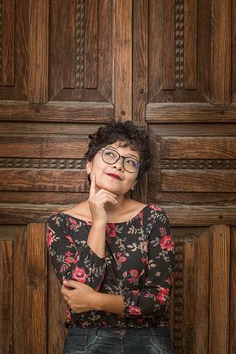 person woman leaning against door while holding her cheek human