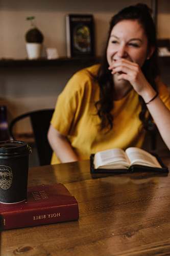 person woman siting on chair near on holy bible human