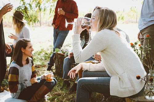 person woman sitting near people while drinking human