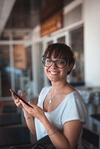 person woman sitting on chair holding phone human