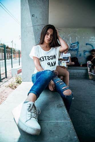 human woman sitting on gray concrete bench during daytime person