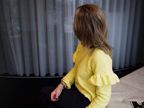 person woman sitting on leather cushion beside glass window human
