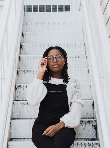 human woman sitting on stair and holding her eyeglasses person