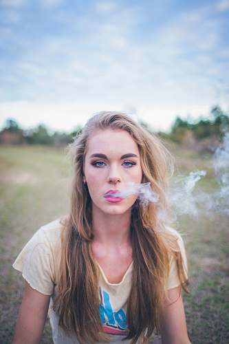 person woman smoking while sitting on green grass human