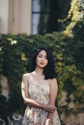 person woman standing in front of wall covered by plants human