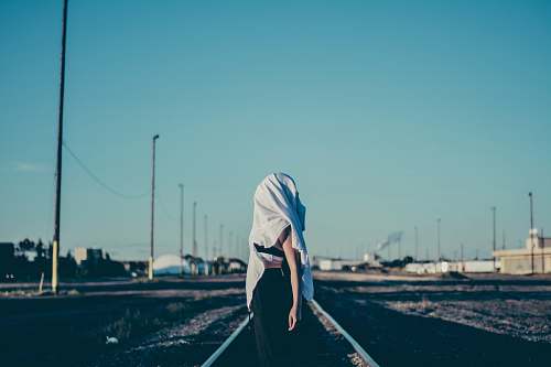 person woman standing in the middle of train rail human