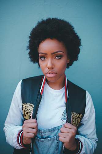 human woman standing near blue wall hair