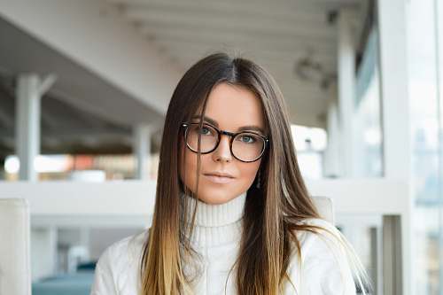 human woman standing near glass window glasses